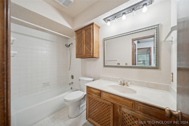 full bathroom with vanity, tile patterned floors, tiled shower / bath, toilet, and a textured ceiling