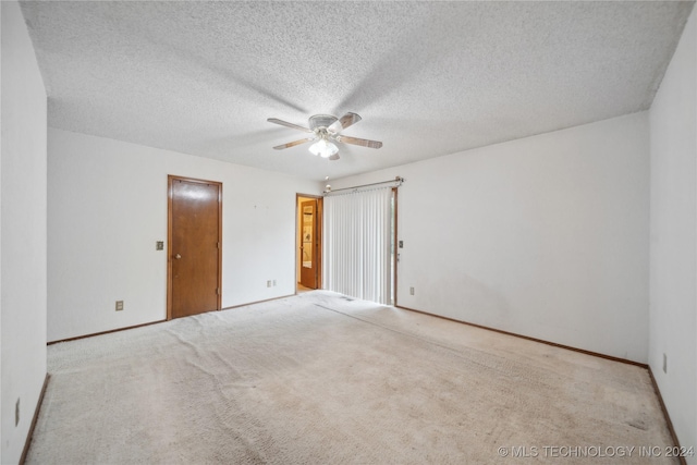 unfurnished room featuring ceiling fan, light colored carpet, and a textured ceiling