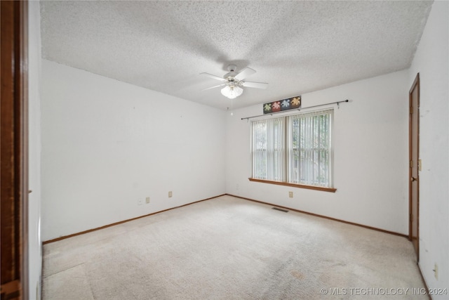 carpeted spare room featuring ceiling fan and a textured ceiling