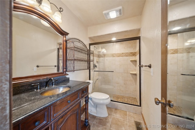 bathroom featuring toilet, tile patterned flooring, vanity, and walk in shower