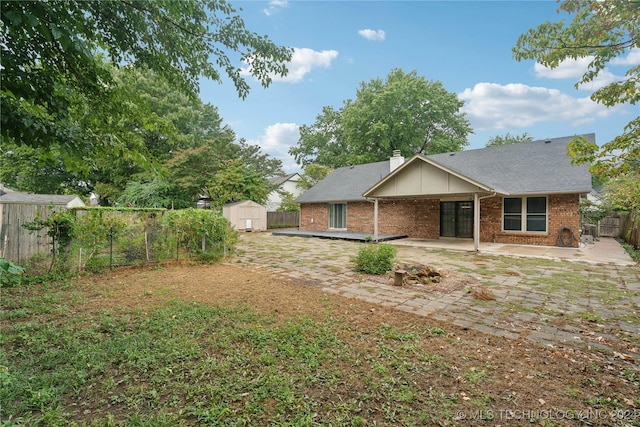 back of property featuring a patio and a storage unit