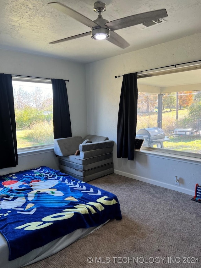 carpeted bedroom featuring a textured ceiling and ceiling fan