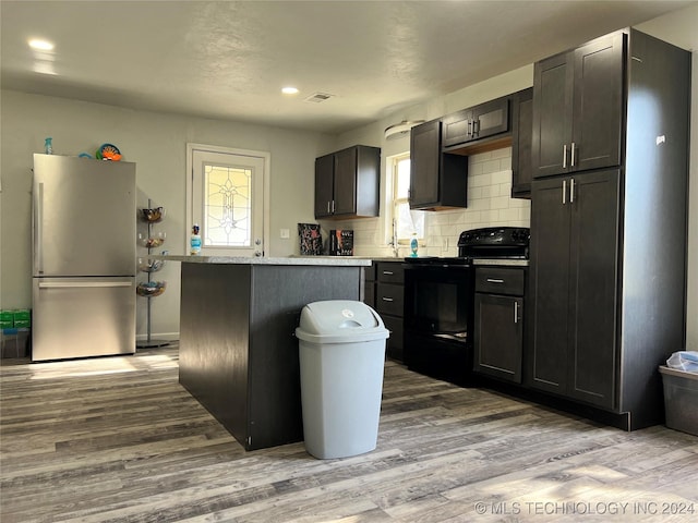 kitchen featuring a center island, a wealth of natural light, black electric range oven, and stainless steel refrigerator