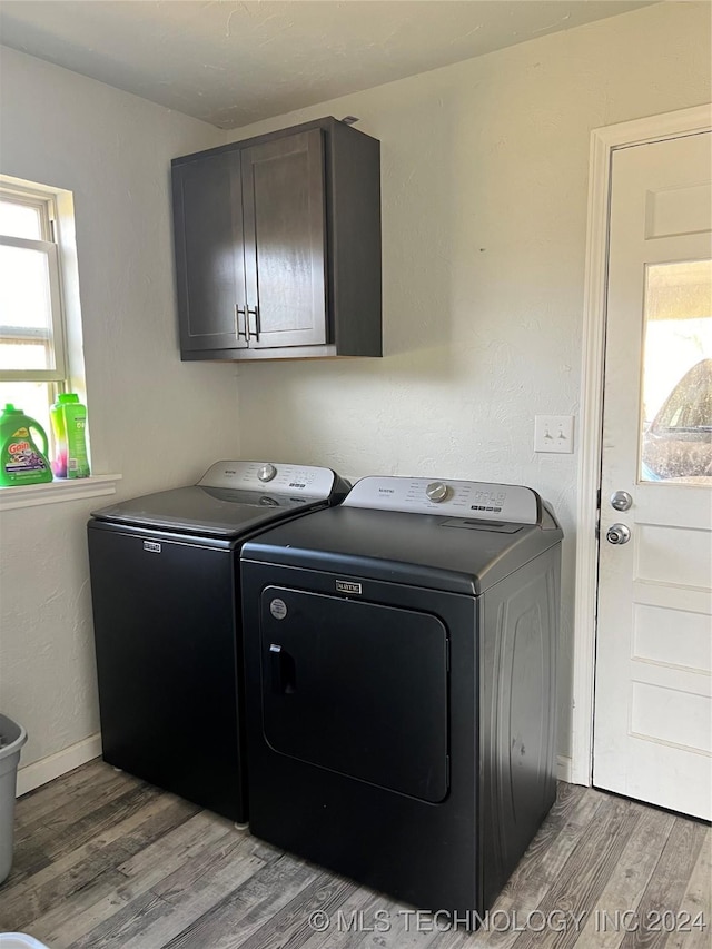 laundry area featuring washer and dryer, cabinets, and light hardwood / wood-style flooring