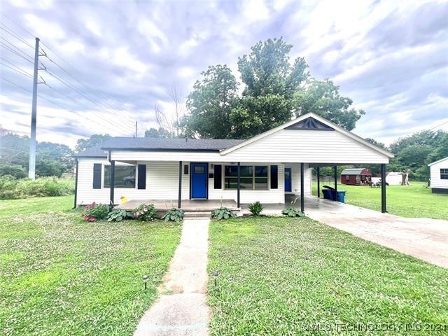 view of front of property featuring a carport, covered porch, and a front lawn