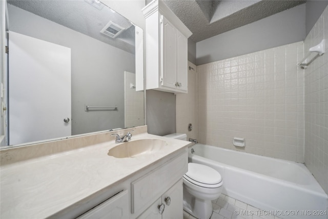 full bathroom with tile patterned flooring, a textured ceiling, toilet, vanity, and tiled shower / bath