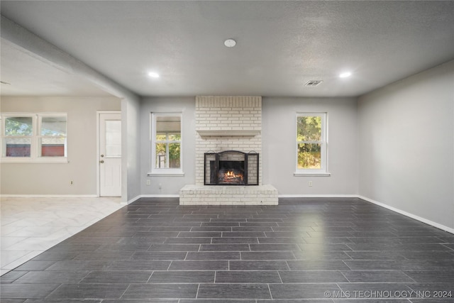 unfurnished living room featuring a textured ceiling and a fireplace