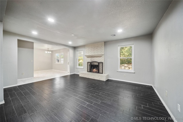 unfurnished living room featuring a textured ceiling, a fireplace, and dark hardwood / wood-style floors