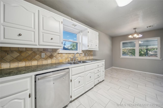 kitchen featuring backsplash, white cabinets, sink, stainless steel dishwasher, and a chandelier