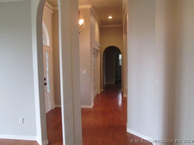 hall with dark hardwood / wood-style flooring and ornamental molding