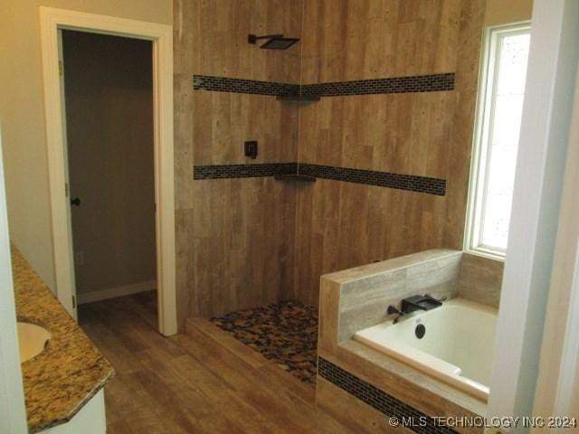 bathroom with plenty of natural light, vanity, wood-type flooring, and shower with separate bathtub