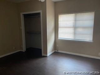 unfurnished bedroom featuring dark hardwood / wood-style flooring and a closet