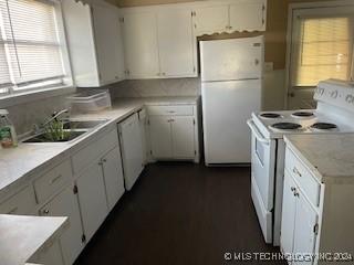 kitchen with white cabinetry, sink, dark hardwood / wood-style floors, and white appliances