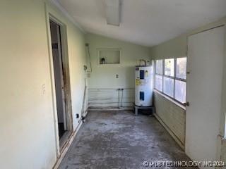 interior space featuring electric water heater and vaulted ceiling