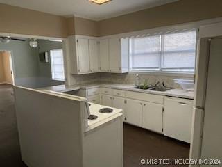 kitchen with kitchen peninsula, white cabinetry, and a healthy amount of sunlight