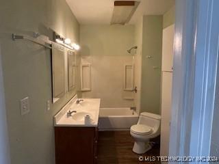 full bathroom featuring vanity, toilet, wood-type flooring, and washtub / shower combination