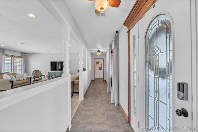 corridor with tile patterned floors and a textured ceiling