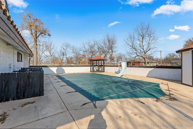 view of swimming pool featuring a gazebo and a water slide