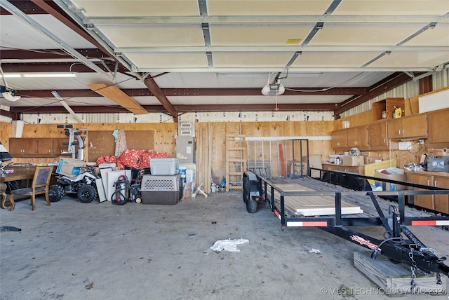 garage with wood walls and a garage door opener