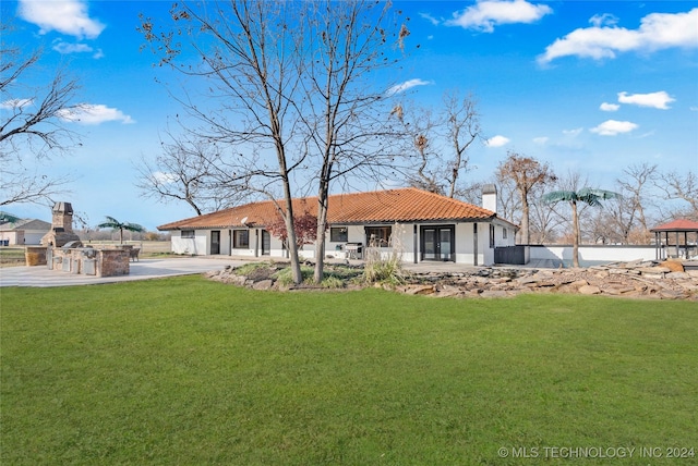 back of house featuring a lawn and area for grilling