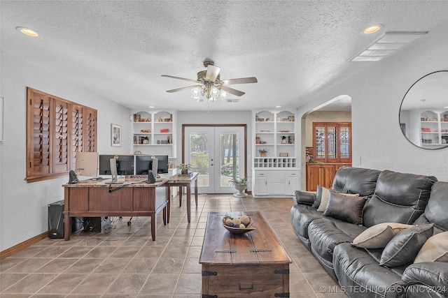 tiled living room featuring french doors, a textured ceiling, ceiling fan, and built in shelves