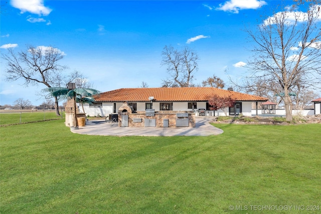 rear view of property featuring a patio, a yard, and area for grilling