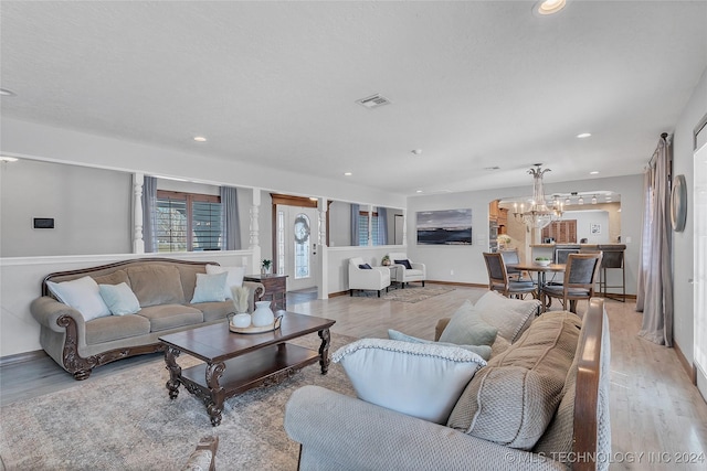 living room with a notable chandelier and light hardwood / wood-style flooring