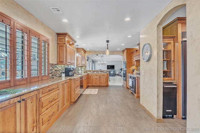 kitchen with hanging light fixtures, stainless steel dishwasher, decorative backsplash, kitchen peninsula, and a chandelier