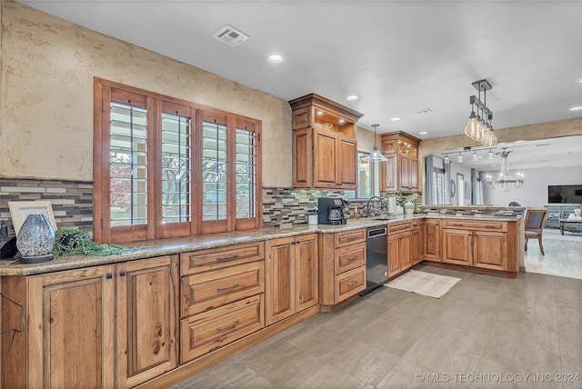 kitchen featuring kitchen peninsula, sink, pendant lighting, an inviting chandelier, and black dishwasher