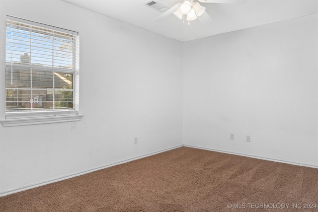 spare room featuring ceiling fan and carpet