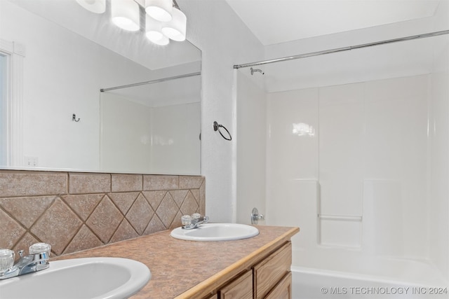 bathroom with decorative backsplash, shower / bath combination, and vanity