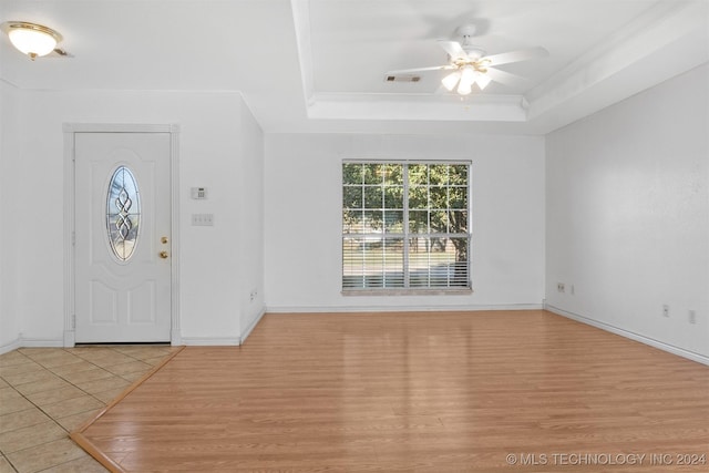 foyer entrance featuring light hardwood / wood-style floors, a raised ceiling, and ceiling fan