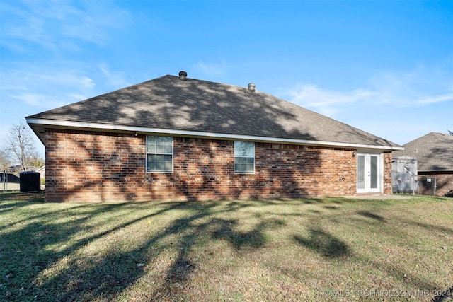 rear view of property featuring a lawn