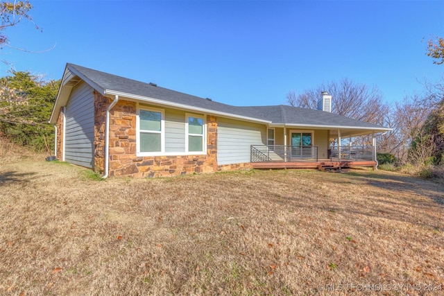 ranch-style home with a front yard and a wooden deck