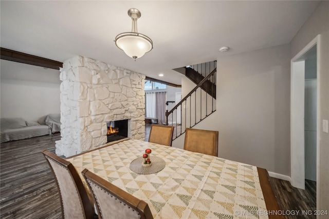 dining area featuring a fireplace and dark wood-type flooring