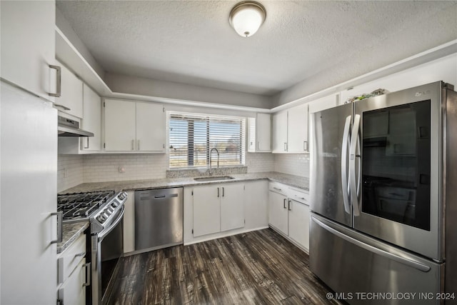 kitchen with sink, stainless steel appliances, tasteful backsplash, dark hardwood / wood-style floors, and white cabinets