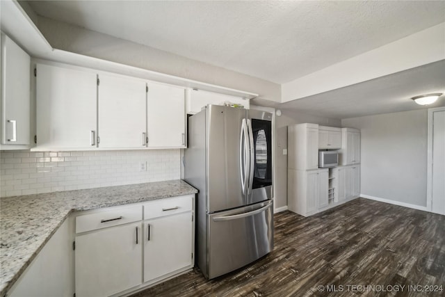 kitchen featuring decorative backsplash, light stone counters, appliances with stainless steel finishes, dark hardwood / wood-style flooring, and white cabinetry