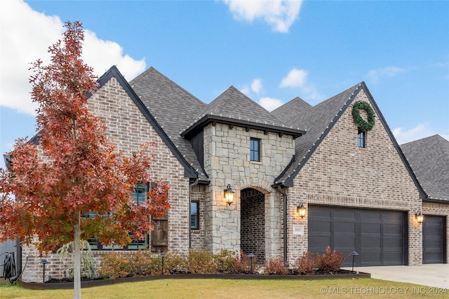 view of front of property featuring a front yard and a garage