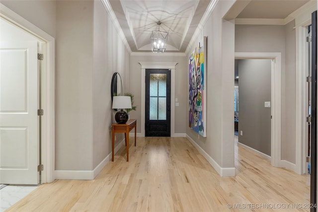 foyer entrance with a chandelier, light hardwood / wood-style floors, and ornamental molding