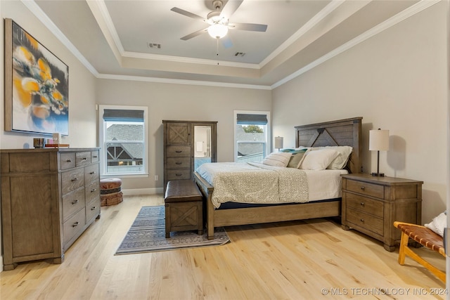 bedroom with a tray ceiling, ceiling fan, light hardwood / wood-style floors, and ornamental molding