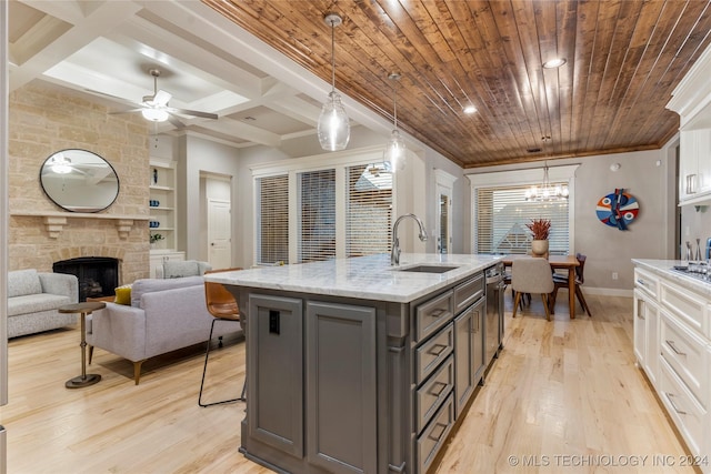 kitchen featuring pendant lighting, a fireplace, white cabinetry, and sink