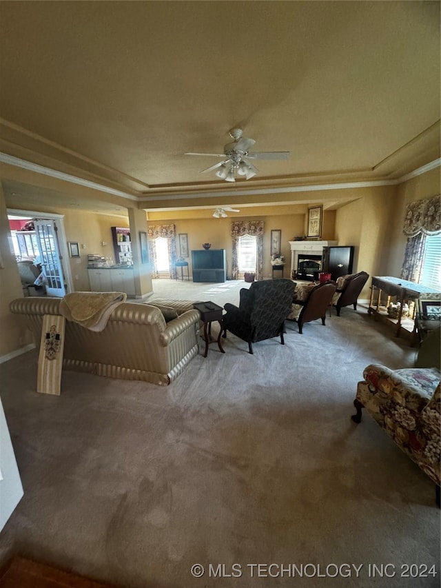 carpeted living room featuring crown molding, ceiling fan, and plenty of natural light