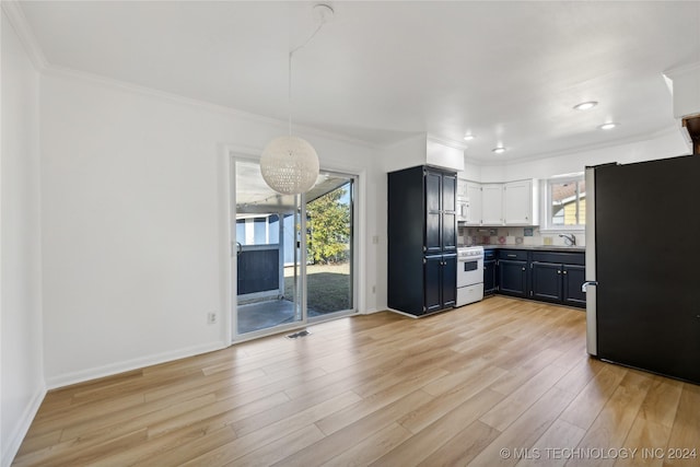 kitchen with a wealth of natural light, stainless steel fridge, hanging light fixtures, and white range