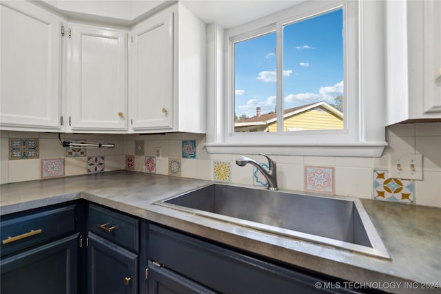 kitchen featuring white cabinetry, blue cabinetry, and tasteful backsplash