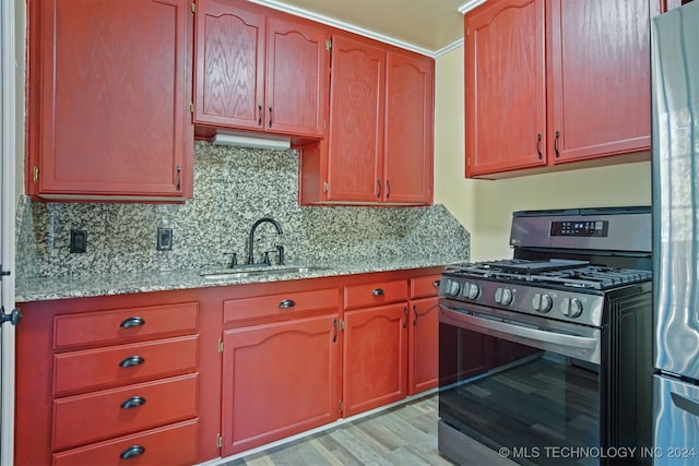 kitchen featuring sink, stainless steel appliances, light stone counters, light hardwood / wood-style flooring, and decorative backsplash