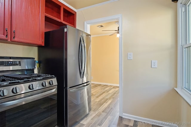 kitchen featuring gas stove, light hardwood / wood-style floors, ceiling fan, and crown molding