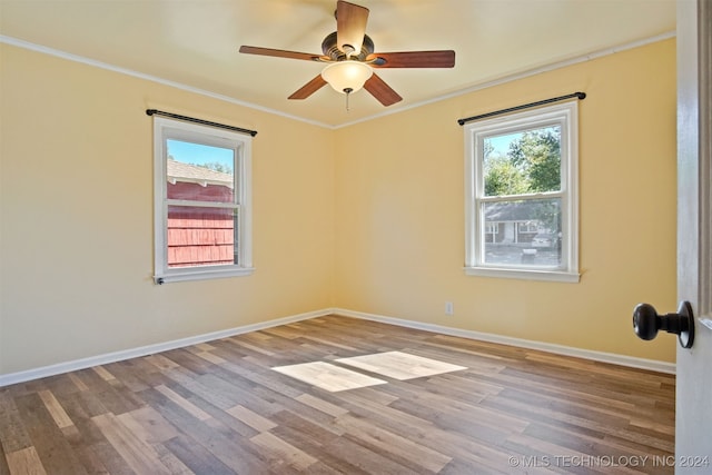 unfurnished room with hardwood / wood-style floors, plenty of natural light, ceiling fan, and crown molding