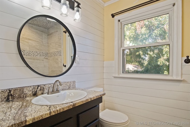 bathroom with vanity, crown molding, and wood walls