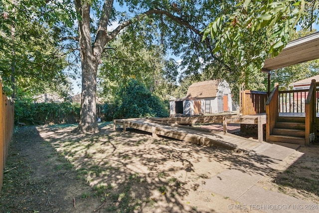 view of yard with a deck and a storage unit