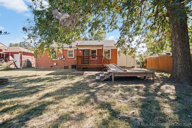 rear view of property featuring central AC, a yard, and a deck